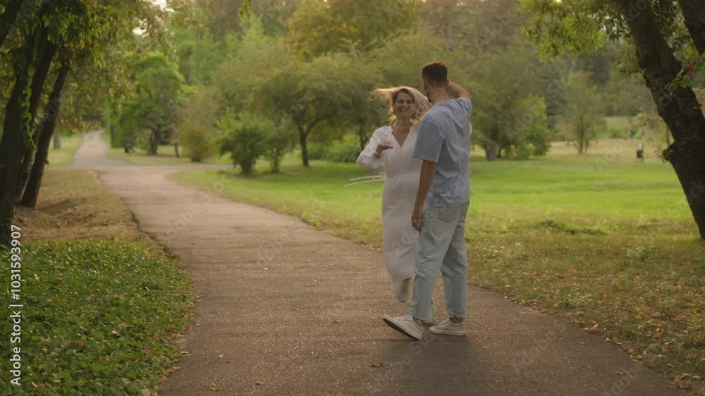 Happy couple dancing in the park on a summer day.