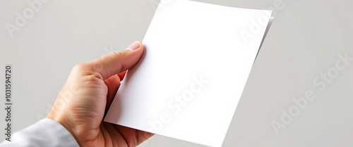 close up of hand holding a blank white paper with copy space for text