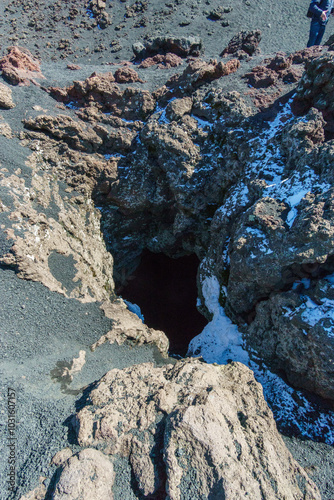 Hole of an inactive fumarole in lava rock at Monti Sartorius Mount Etna with snow during winter time, Catania, Sicily, Italy