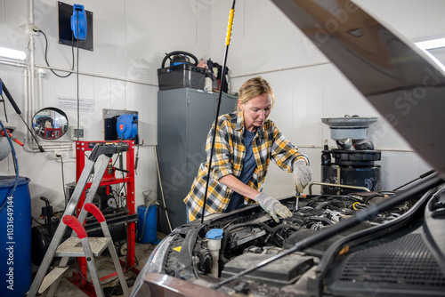 female mechanic working on a car in garage photo