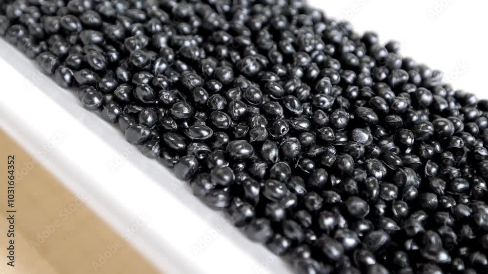 Black polymer granules in a garbage recycling plant. Raw materials for recycled plastic are used in manufacturing. Black polymer granules in a garbage recycling plant. Raw materials for recycled plastic are used in manufacturing.