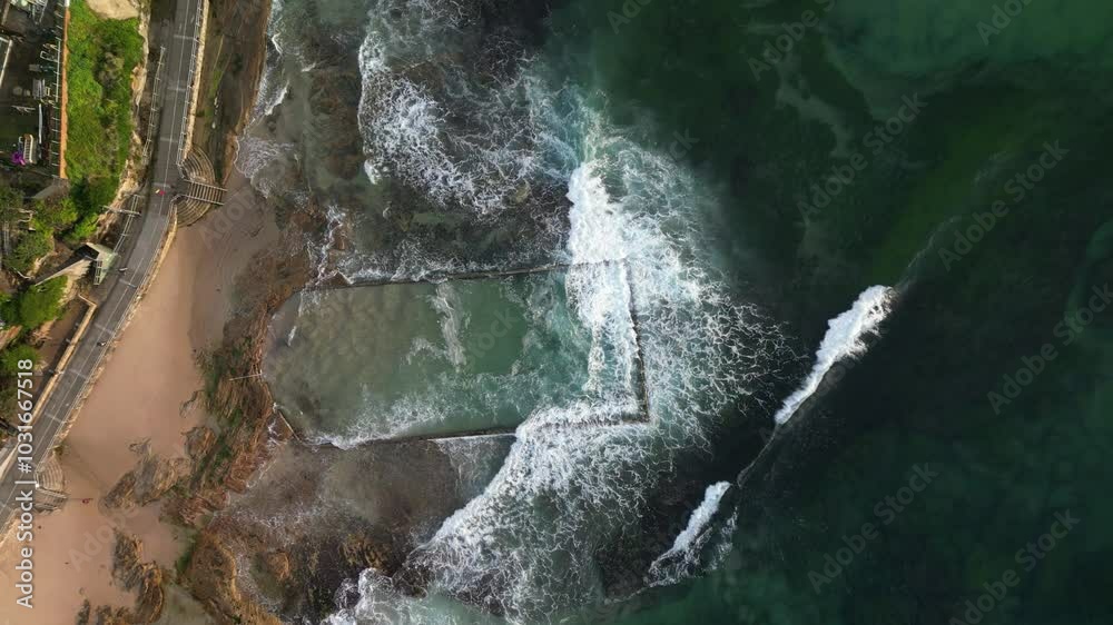Aerial views of Cronulla ocean tide pool with incoming waves washing into pool