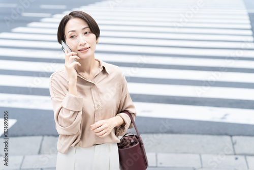 ビル街で通話をする女性