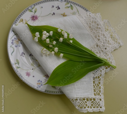 Lilies of the valley on a white napkin with Vologda lace photo