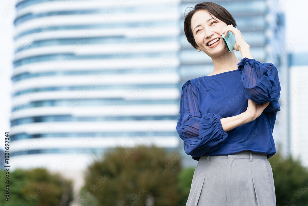 ビル街で通話をしている女性 ビル街で通話をしている女性