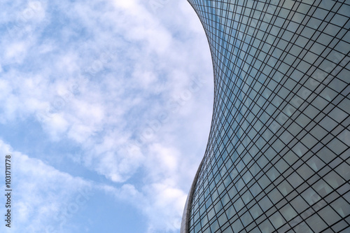 Angled view of modern skyscrapers in business district against blue sky. Looking Up high-rise office buildings.