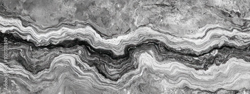 Abstract black and white layered rock texture with wavy patterns.