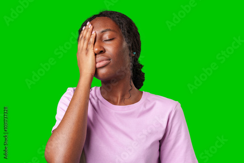 A woman expressing frustration while standing in front of a bright green background