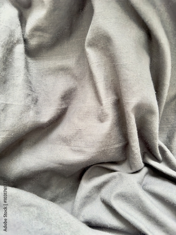 Fototapeta premium Softly draped gray fabric creates a minimalist, textured background, perfect for modern design projects or social media content. Ideal for adding subtle elegance to branding, mockups.