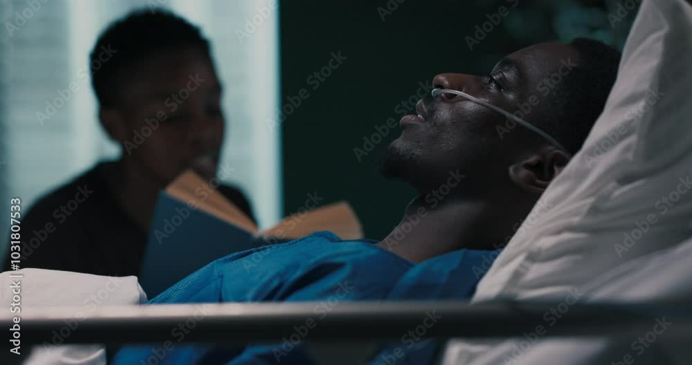 African woman enjoys a book while sitting beside an African man in the hospital. African woman enjoys a book while sitting beside an African man in the hospital.