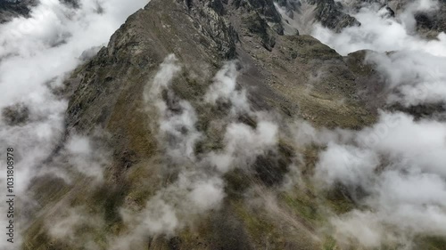 Aerial drone view of a beautiful mountain range with clouds and a sunny day in the Pyrenees, France
