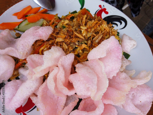 Mie Jawa or Bakmie Jawa, Javanese traditional noodle covered with kerupuk or crackers served on plate, Close up.