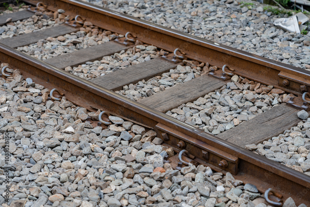 Close-up of railway tracks with wooden sleepers and gravel stones along the path Close-up of railway tracks with wooden sleepers and gravel stones along the path