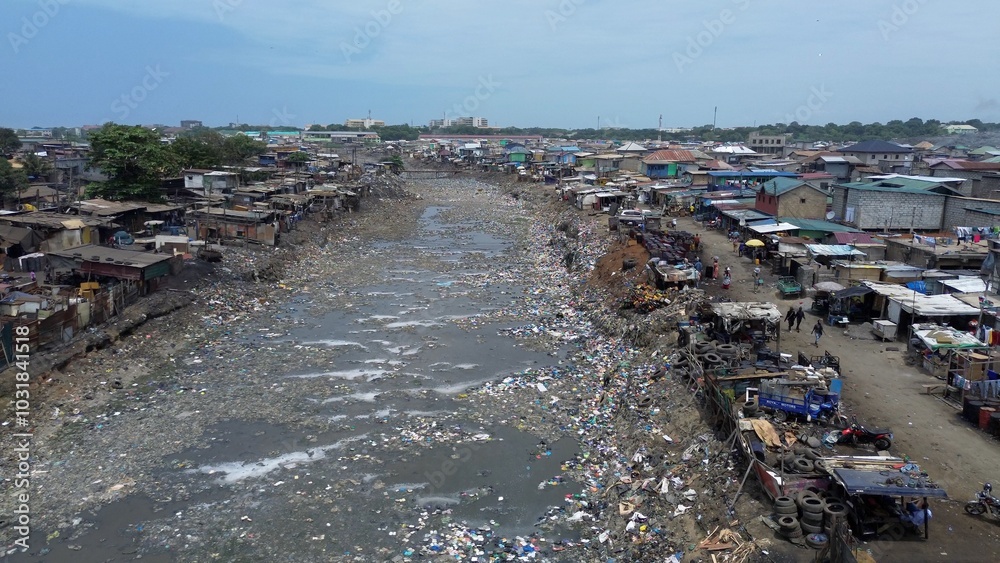 People live in slums immersed immersed in toxic waste that poisons the land and river waters in Africa Africa Ghana AGBOGBLOSHIE. high environmental pollution area , Climate change global warming