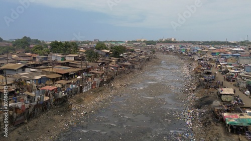 Obraz na płótnie People live in slums immersed immersed in toxic waste that poisons the land and river waters in Africa Africa Ghana AGBOGBLOSHIE. high environmental pollution area , Climate change global warming w salonie