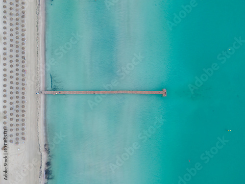 Aerial drone view of wooden pier and turquoise waters at Playa de Muro, Alcudia, Mallorca