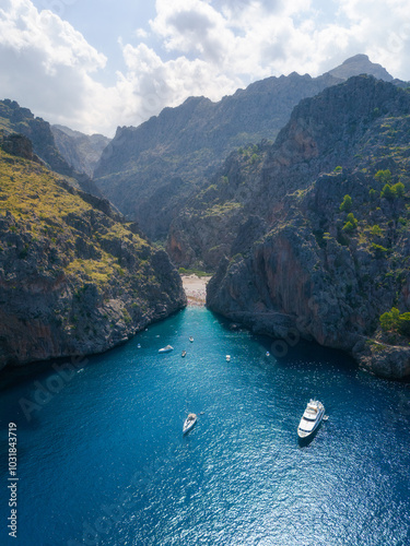 Aerial drone view of Sa Calobra cove and Torrent de Pareis with boats and swimmers, Mallorca