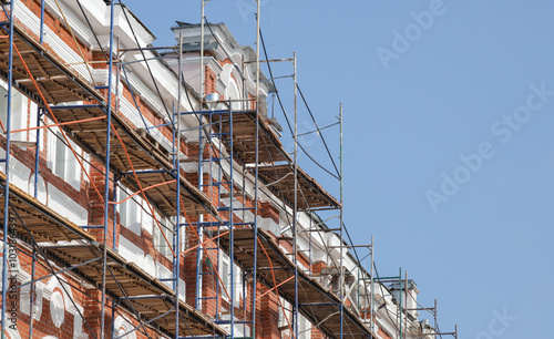 Wallpaper Mural A building under construction with scaffolding and a blue sky in the background Torontodigital.ca