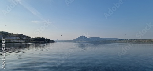 sea gulls above lake Most under the peak Hněvín with castle and lookout, artificial post mining revitalised coal mine small power plant aroun