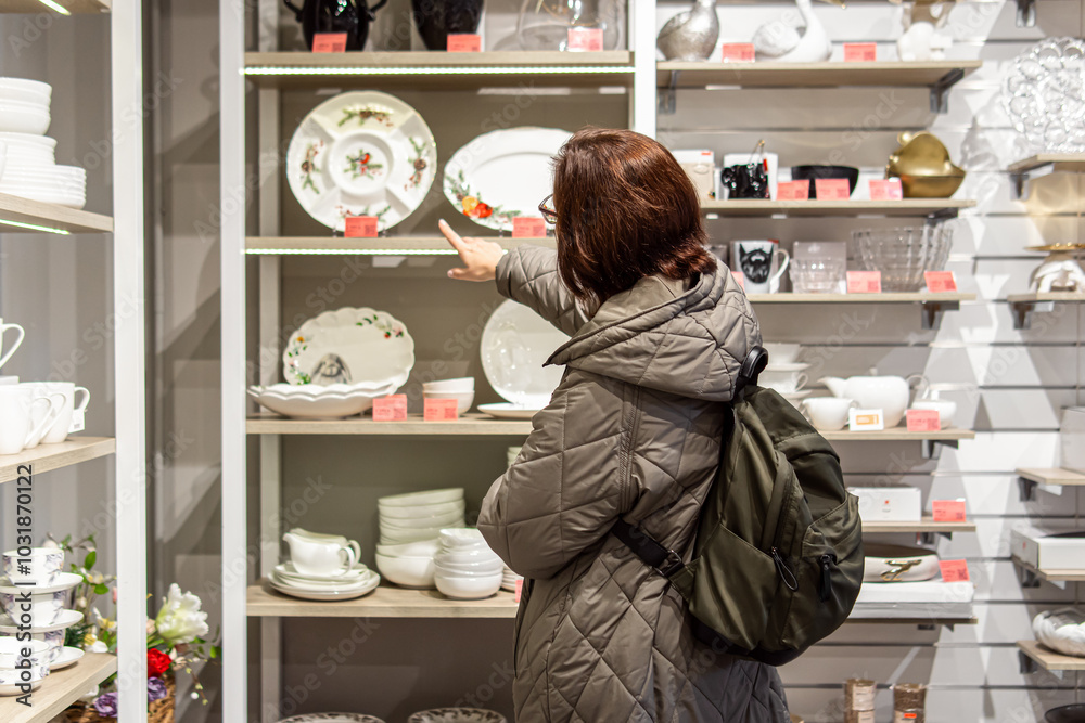 Woman chooses dishes on sale. Christmas dishes Woman chooses dishes on sale. Christmas dishes