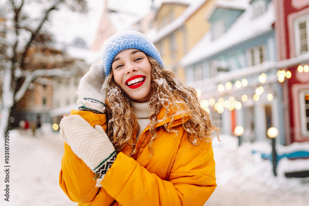 Young woman tourist walks along winter streets decorated with luminous garlands. Winter holidays. Christmas fair.