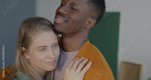 Close-up of loving African American man hugging and kissing Caucasian woman girlfriend expressing love indoors at home. Relationship and love concept.