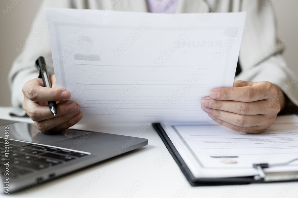 Business woman employer holding resume hiring recruit looking cv resume to hire candidates, analyzing information before job interview. Recruitment concepts Business woman employer holding resume hiring recruit looking cv resume to hire candidates, analyzing information before job interview. Recruitment concepts
