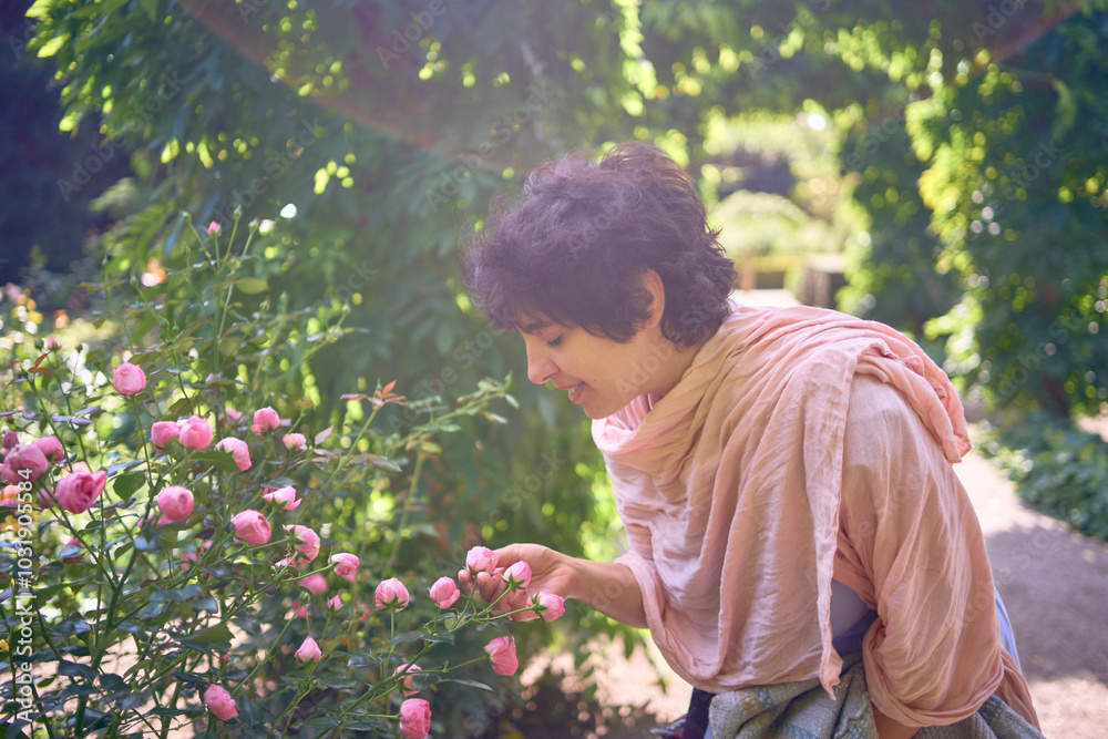 young plus size woman in dress and shawl enjoying pink roses in Frederiksberg Park botanical garden, Copenhagen young plus size woman in dress and shawl enjoying pink roses in Frederiksberg Park botanical garden, Copenhagen