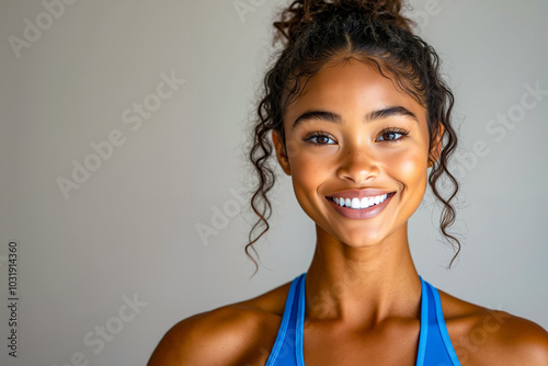 A woman in a blue sports bra smiling at the camera