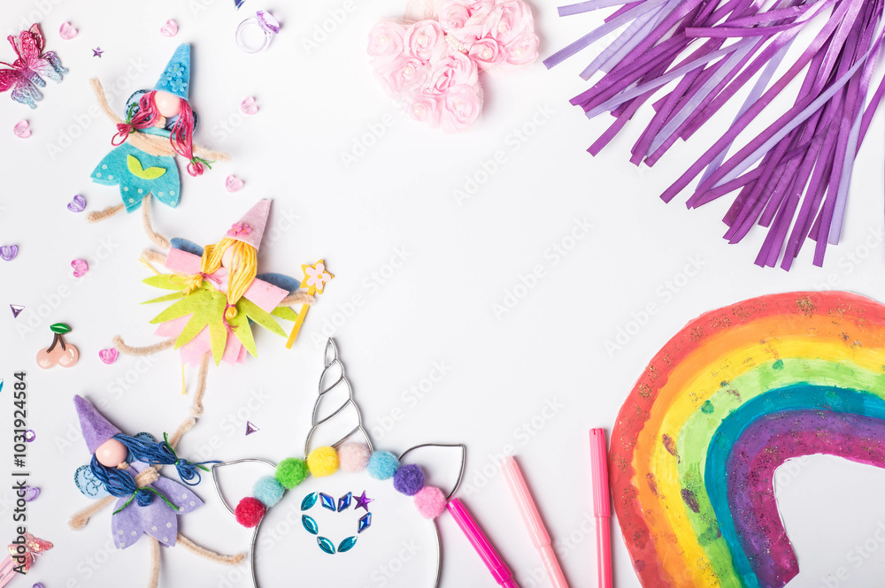 Hand-painted rainbow with fairy dolls and glitter pens for magical creativity. Whimsical fairies and sparkling accessories. Craft supplies featuring fairies with space for notes. Flat lay. Top view. Hand-painted rainbow with fairy dolls and glitter pens for magical creativity. Whimsical fairies and sparkling accessories. Craft supplies featuring fairies with space for notes. Flat lay. Top view.