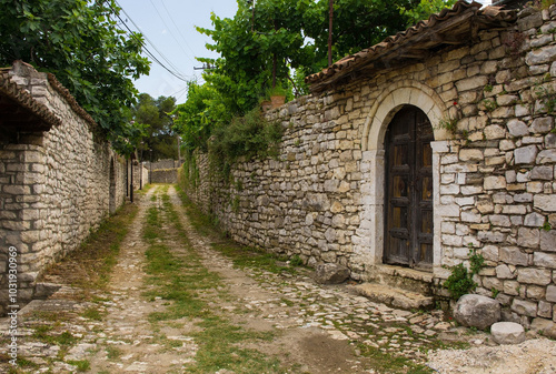 A grassy cobblestoned lane in the historic residential quarter of the castle district, Kalaja, of Berat in southern Albania. Traditional stone walls. UNESCO World Heritage Site listed
