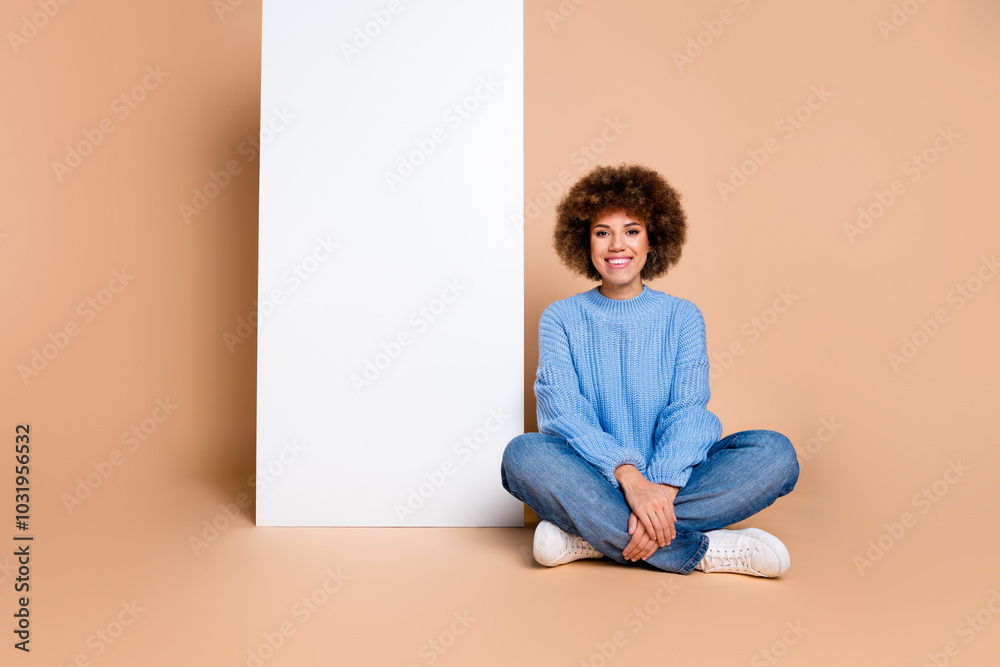 Full size photo of optimistic girl wear blue sweater sit near offer on white board empty space isolated on pastel color background Full size photo of optimistic girl wear blue sweater sit near offer on white board empty space isolated on pastel color background