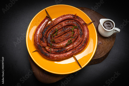 LInguiça calabresa na grelha, servida como aperitivo com molho picante photo