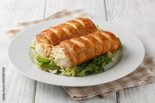 Delicious French puff pastry rolls with gruyere cheese and bechamel sauce close-up in a plate on the table. Horizontal