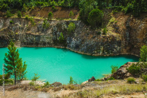 A striking turquoise lake surrounded by rocky cliffs and lush vegetation