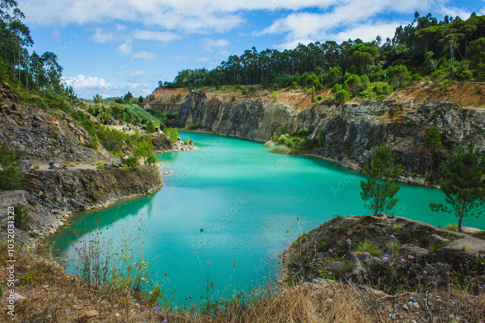 Fototapeta premium A striking turquoise lake surrounded by rocky cliffs and lush vegetation