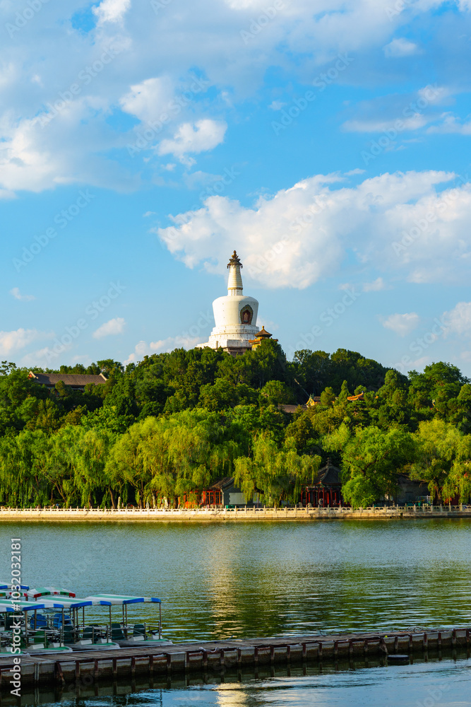 The iconic White Pagoda of Beihai Park at sunset under blue sky with white cloud in Beijing, China The iconic White Pagoda of Beihai Park at sunset under blue sky with white cloud in Beijing, China