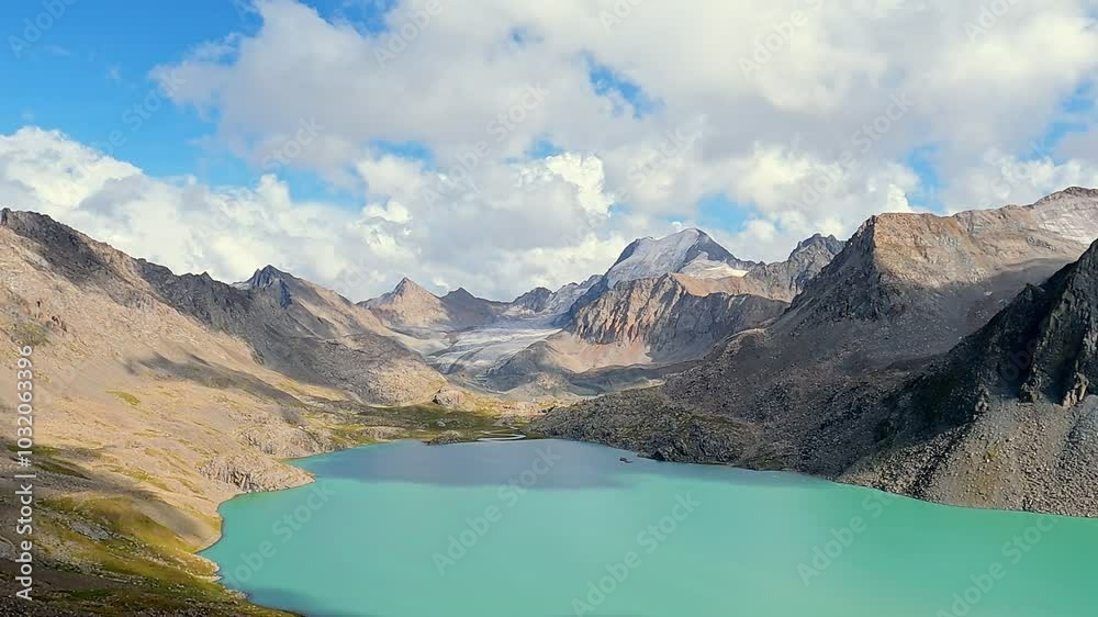 Stop motion shooting. Timelapse. Thick white clouds floating over mountainous terrain with tranquil lake. Panorama landscape with clouds float over the mountains. Stop motion shooting. Timelapse. Thick white clouds floating over mountainous terrain with tranquil lake. Panorama landscape with clouds float over the mountains.
