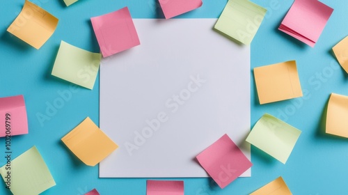 Blank white paper surrounded by colorful sticky notes on a blue background