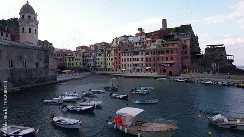 Charming coastal village of Italys Cinque Terre embraces vibrant boats at sunset photo