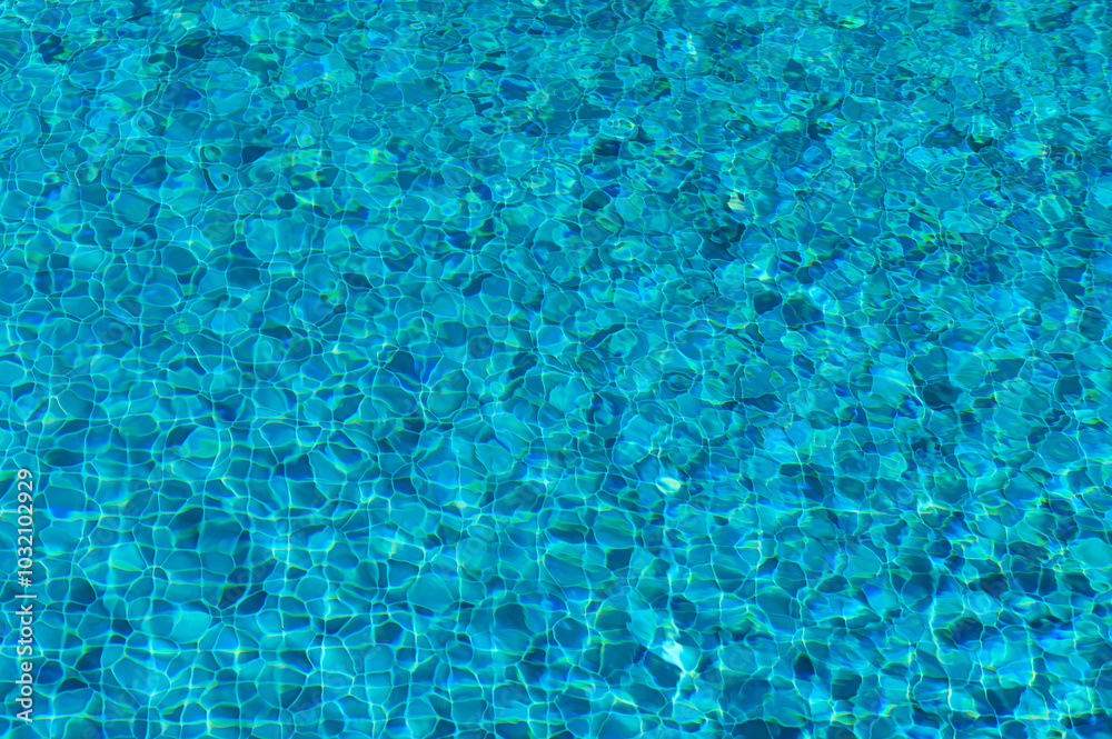 The Shimmering Turquoise Ripples Dance in the Sunlight Above a Tranquil Swimming Pool on a Bright Summer Afternoon