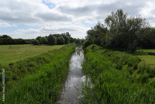River way running between two large green hills in the British country.