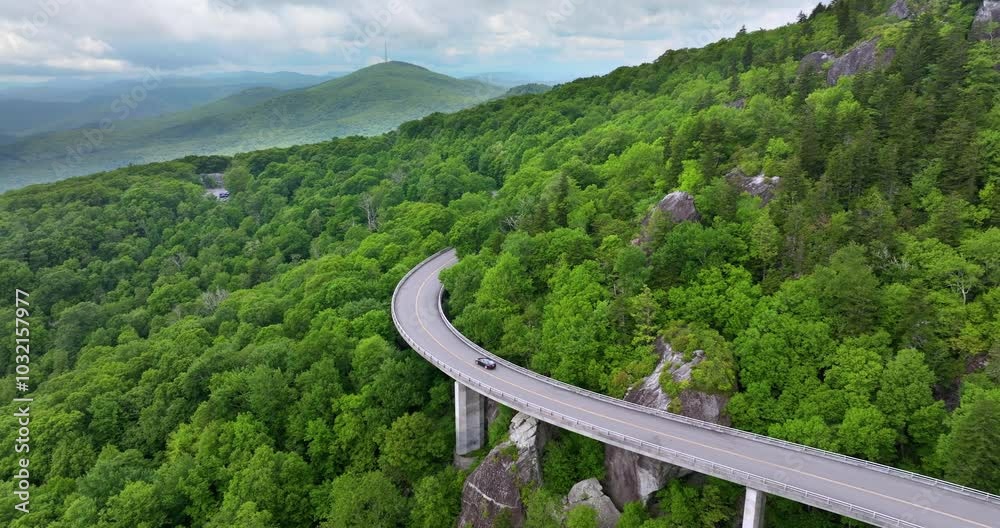 Linn Cove Viaduct on Blue Ridge Parkway road in summer woods of Appalachian mountains with green canopies in colorful forest. Road trip driving in wild nature in summertime season