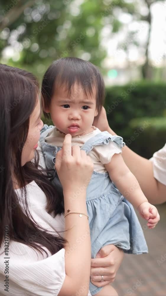 A Taiwanese family, consisting of a father in his 30s, a mother in her 20s, and their 1-year-old daughter, are walking apartment in Taichung City, Taiwan.Slowmotion, Vertical Video. A Taiwanese family, consisting of a father in his 30s, a mother in her 20s, and their 1-year-old daughter, are walking apartment in Taichung City, Taiwan.Slowmotion, Vertical Video.
