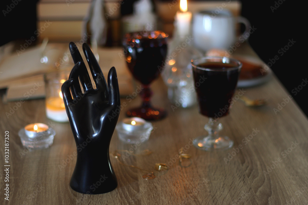 Books, lit candles, red wine, snacks and various deocration on the table. Dark academia or Halloween concept. Selective focus. Books, lit candles, red wine, snacks and various deocration on the table. Dark academia or Halloween concept. Selective focus.