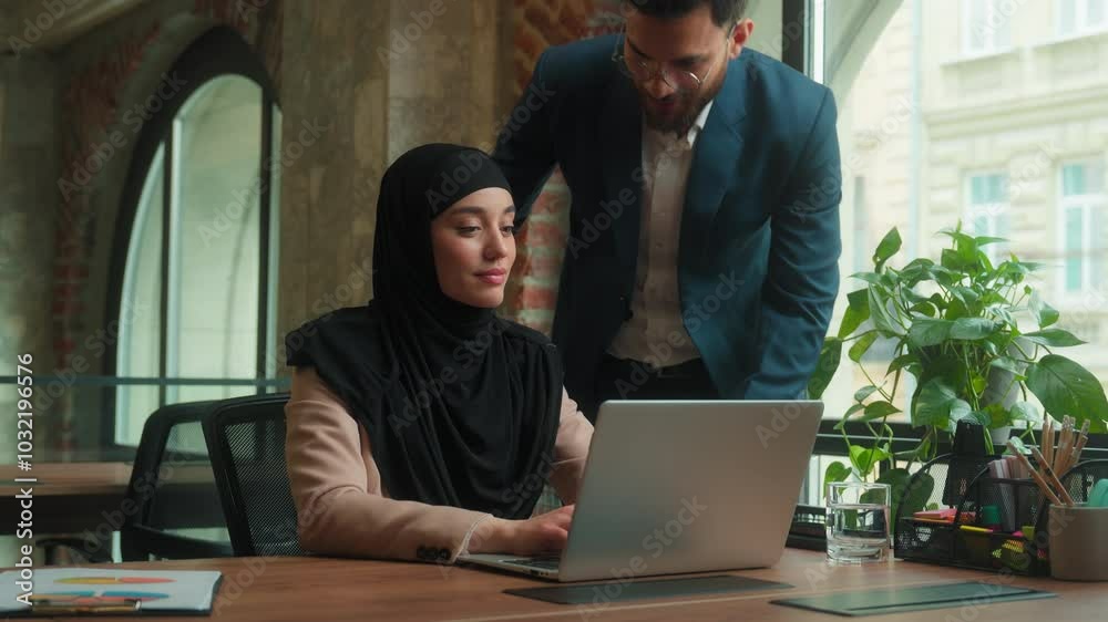 Muslim female woman hijab work online laptop Arabian man male boss leader mentor come in office help employee multiethnic businessman businesswoman talk discuss project business partnership in office