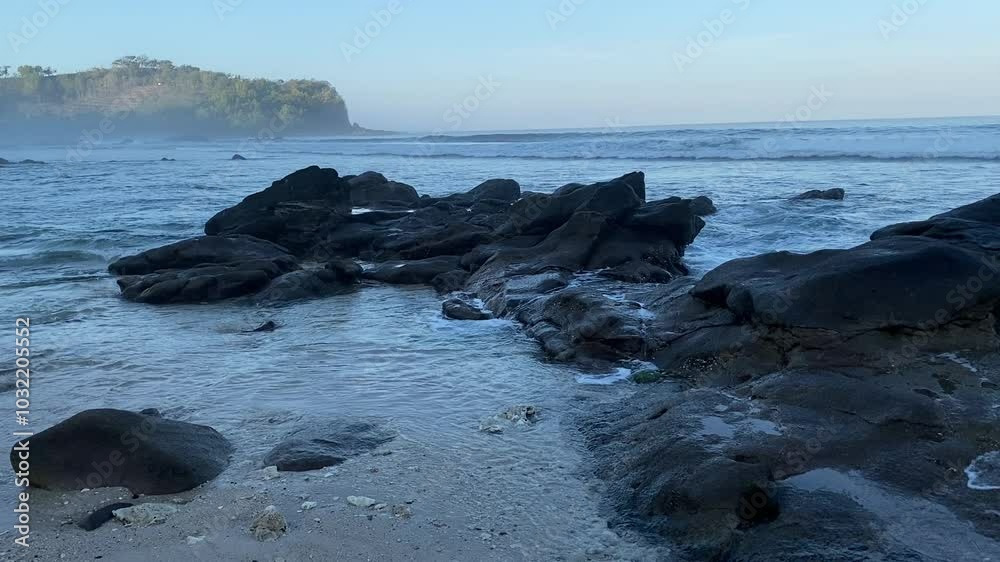 The ocean waves crashing on the rocks by the shore The ocean waves crashing on the rocks by the shore