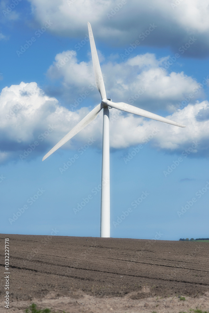 Blue sky, clouds and landscape with wind turbine for renewable energy outdoor to produce electricity. Field, nature and recycling with windmill in nature environment for conservation or power supply Blue sky, clouds and landscape with wind turbine for renewable energy outdoor to produce electricity. Field, nature and recycling with windmill in nature environment for conservation or power supply