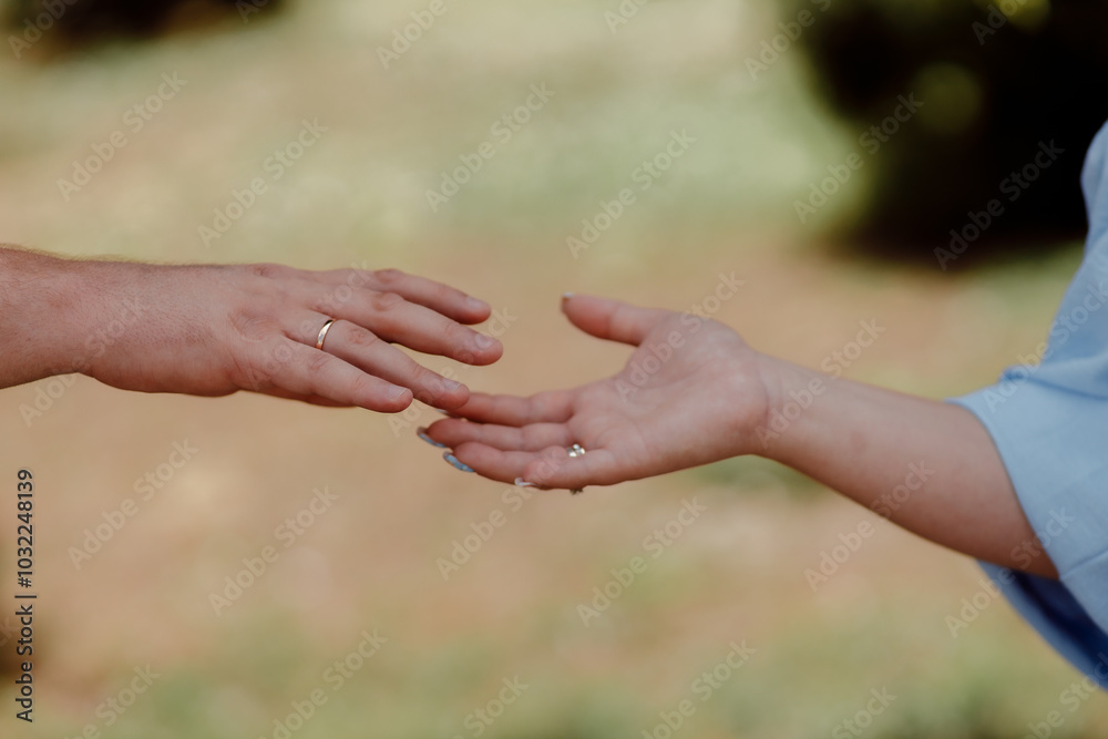 A couple in love touches each other with their hands. Love story of a young couple in love. Wedding rings on ring fingers. Concept of a marriage proposal. Starting a family. A couple in love touches each other with their hands. Love story of a young couple in love. Wedding rings on ring fingers. Concept of a marriage proposal. Starting a family.