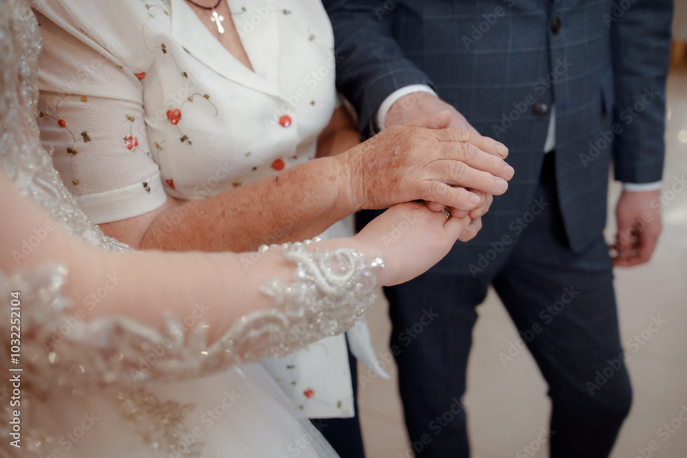 A couple in love touches each other with their hands. Love story of a young couple in love. Wedding rings on ring fingers. Grandmother blesses the newlyweds. Starting a family. A couple in love touches each other with their hands. Love story of a young couple in love. Wedding rings on ring fingers. Grandmother blesses the newlyweds. Starting a family.